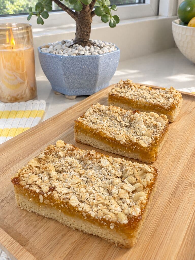 Barras de mango y lulo con streusel por encima, sobre una tabla de madera