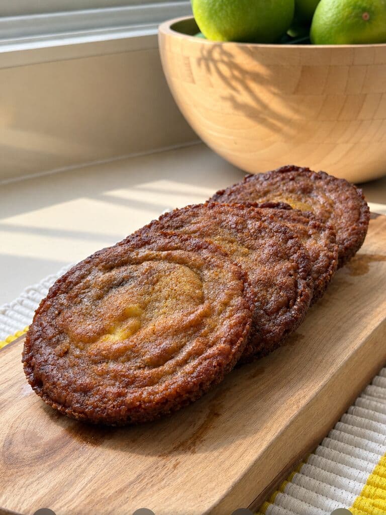 Galletas de cheesecake doradas sobre una tabla de madera