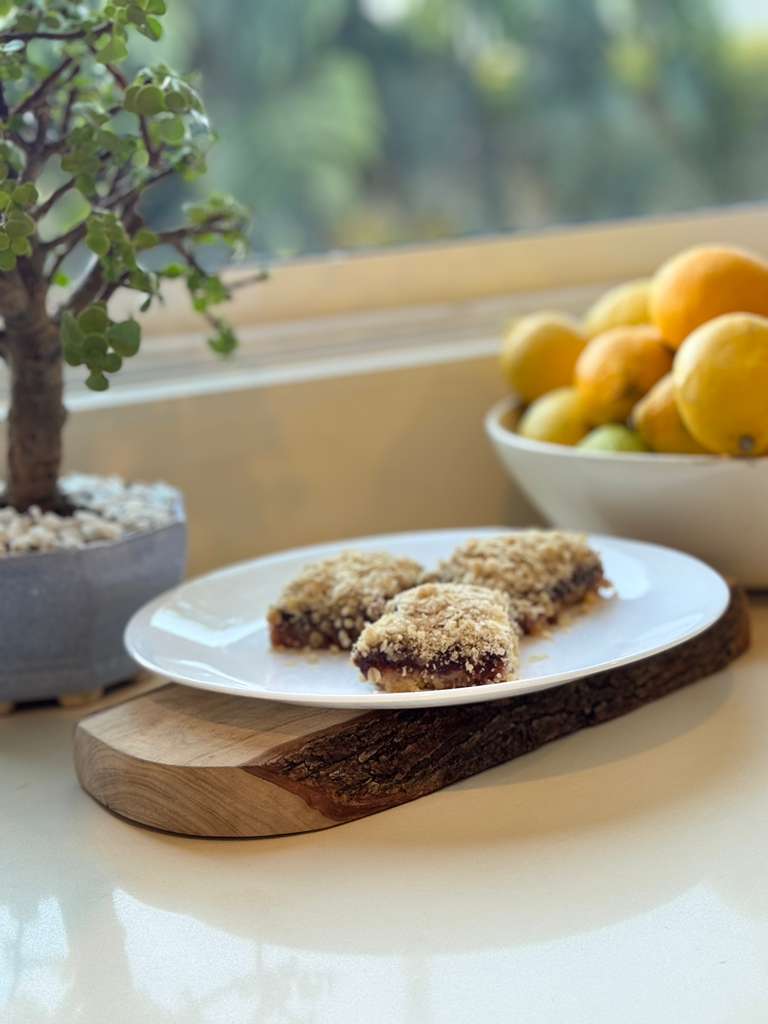 Galletas de guayaba y fresa con streusel en un plato blanco sobre una tabla de madera